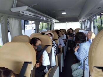 バス車内でガイドの説明を聞く参加者の写真